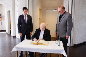 Bürgermeister Christian Pospischil gratuliert. Erbischof Becker trägt sich ins goldene Buch der Stadt ein.