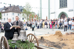 Erzbischof Becker unterschreibt das Holzstück, mit dem das erste Mal die Glocken angeschlagen wurden.